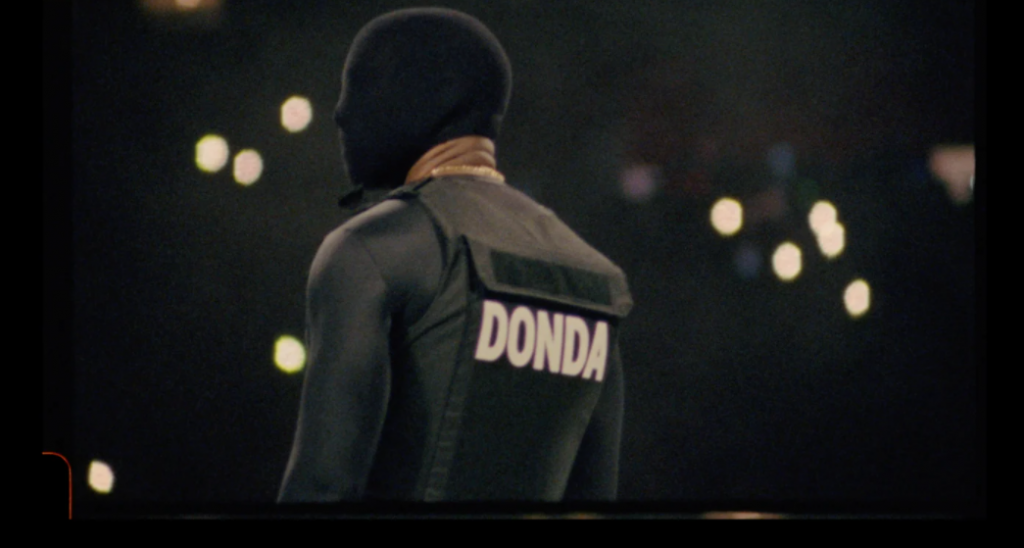 Kanye West se apresenta no Mercedez-Benz Stadium (EUA) com máscara no rosto inteiro e colete à prova de balas escrito o nome do álbum "Donda". Foto de Philey Sanneh/DONDA/divulgação.