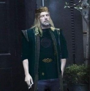 Memes HOTD: adaptação do meme do Ben Affleck fumando com peruca loira, coroa e roupa de rei como se fosse o Viserys Targaryen. Imagem: Reprodução.