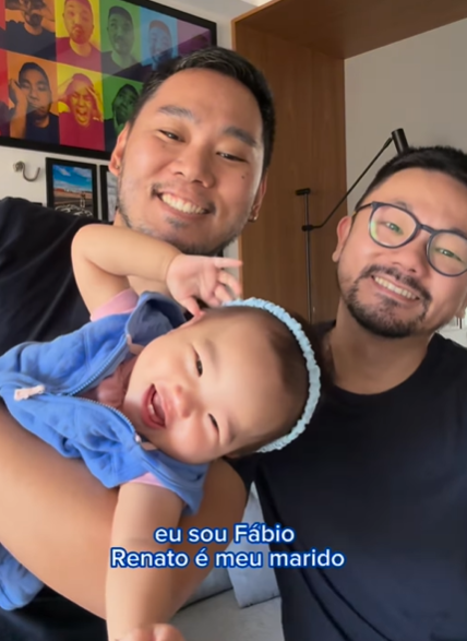 Fabio Riudi - com o Instagram Olha o apê deles. Casal Fabio e Renato, que se tornaram pais de Emily com a ajuda da irmã de um deles também participaram da campanha da MAM Baby. Criadores de conteúdo em paternidade, arquitetura e decoração. Imagem: Instagram Fabio Ruidi. 2024.